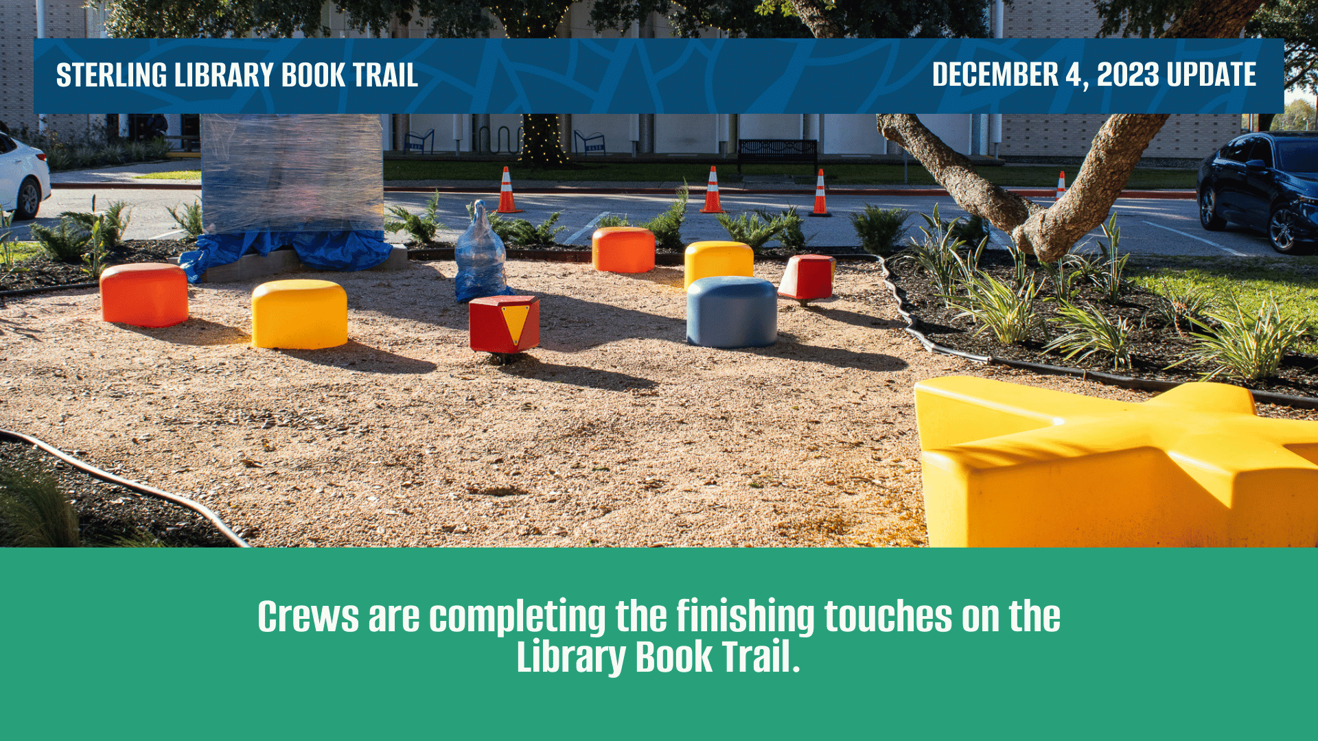 Colorful reading chairs set in a semi circle around a large book sculpture covered by a tarp.